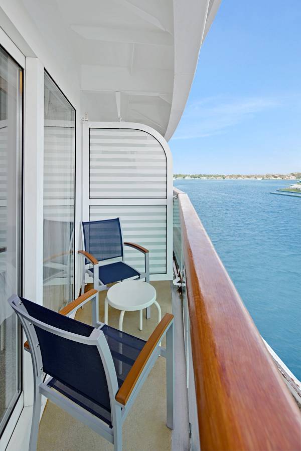 Camera Deluxe Vista mare con balcone, tavolino e sedie per godersi una vista mozzafiato durante la crociera Royal Caribbean